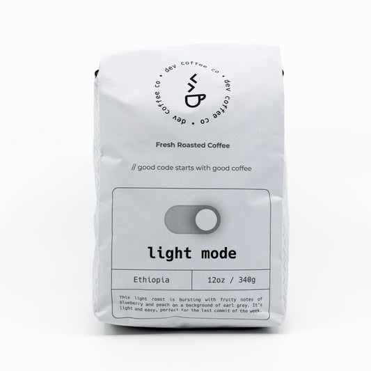Front of bag of 12oz "Light mode" Premium Coffee from Dev Coffee Co. Good code starts with good coffee.